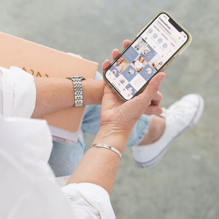 Sarah Hodges holding phone with social media